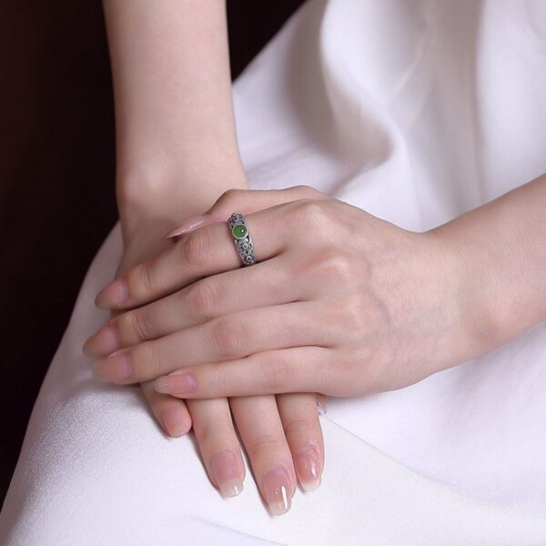 silver ring with jade stone on finger